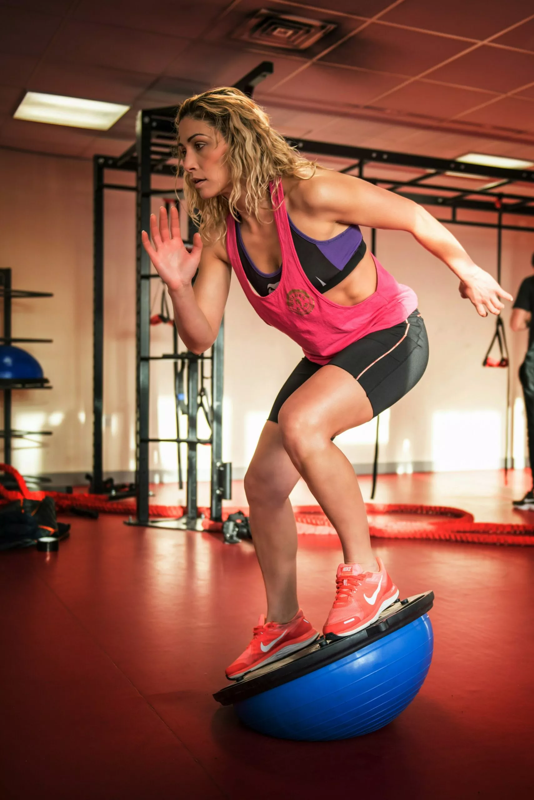 Femme en tenue de sport s'entraînant avec un équipement de fitness.